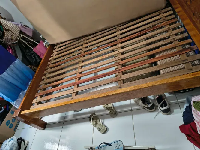 Cama de madeira com cabeceira entalhada