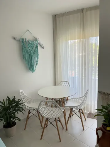 Mesa Eiffel branca com 4 cadeiras vazadas.