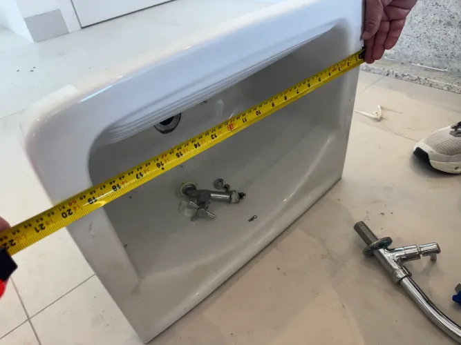 Tanque em cerâmica de parede com torneira metálica de mesa e sifão