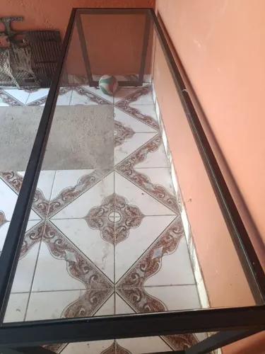Mesa de vidro com base de ferro.