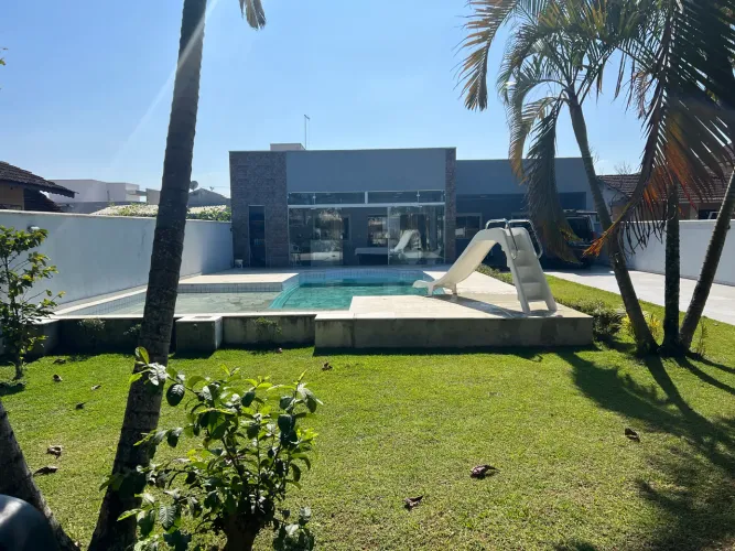Casa com piscinas a uma quadra do mar.