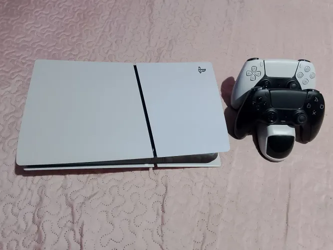 PS5 , dois controles e base de carregamento e o jogo FIFA 26
