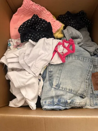 Caixa com roupas adulto e sapato infantil para doação 