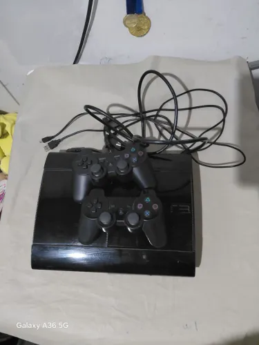 Ps3 super slim desblo com muita loja de jogos com dois controle e um cabo de caregamento 