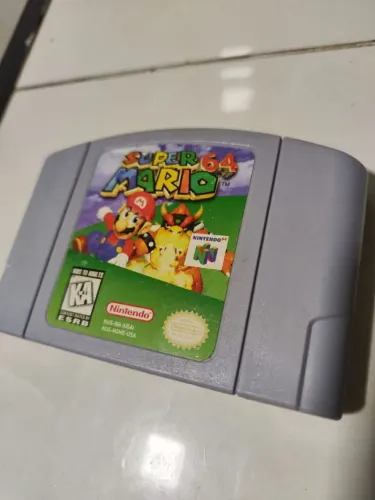Cartucho original Super Mario 64 com caixa e berço reprôs