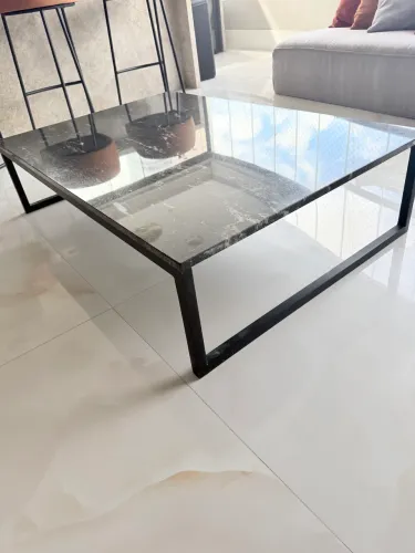 Mesa de centro muito elegante. O tampo em pedra natural e a base metálica preta