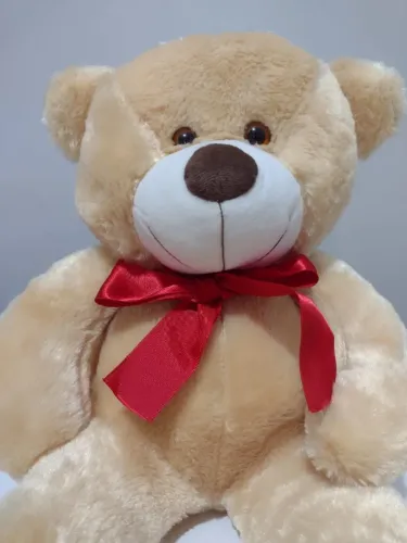 urso de pelúcia grande na cor creme claro com laço vermelho 
