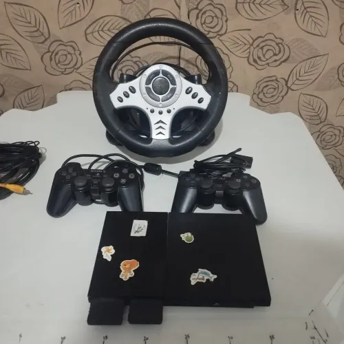 PS2 com dois controles e um volante 