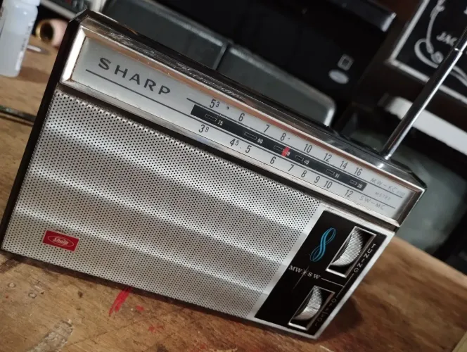 Rádio antigo de mão Sharp AM, funcionando.