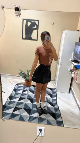 Saia preta com detalhe e blusa marrom com estampa