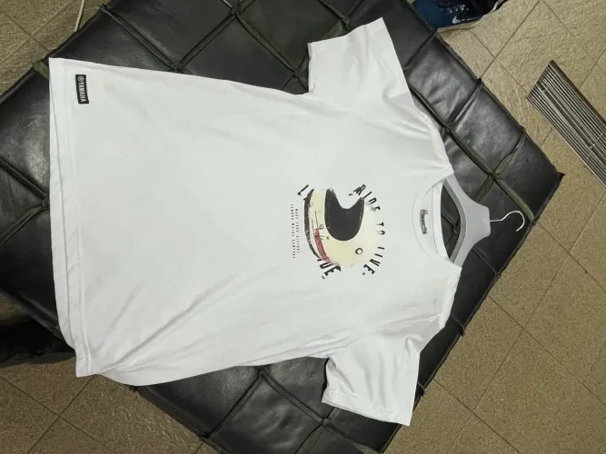 uma camiseta branca Yamaha com estampa de capacete e o texto "RIDE TO LIVE"