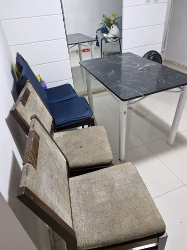 Uma mesa com tampo de mármore acompanha 04 cadeiras em Bom estado todas , precisando!