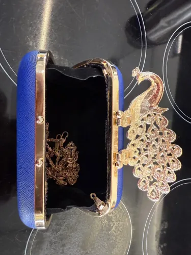 Bolsa de mão azul com detalhe de pavão dourado