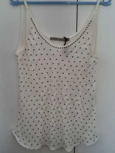 Camiseta alça offwhite com aplicações de tachinhas dourados na frente.