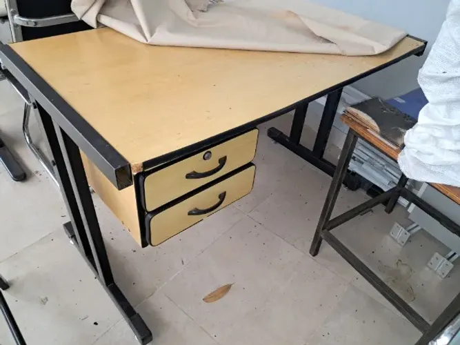 Mesa de trabalho com gaveta e chaves.