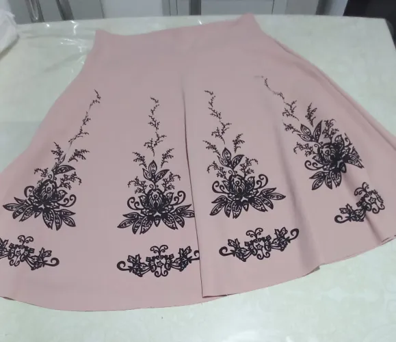 Uma saia gode nudi com forro e detalhes  de flores  preta.
