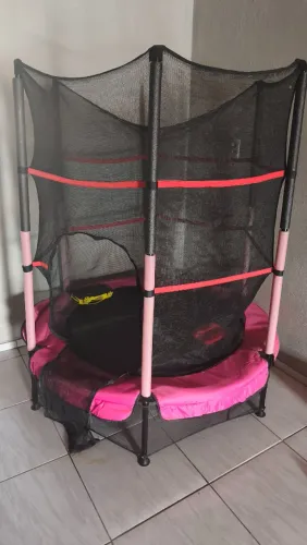 Cama elástica infantil rosa com rede de proteção