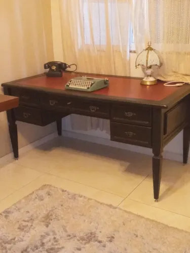 Escrivaninha antiga estilo clássico Inglês, estrutura em madeira escura e tampo vermelho.