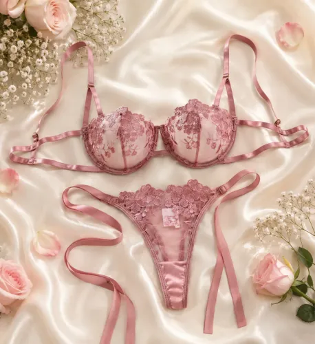 Conjunto de lingerie rosa com renda floral e detalhes em fita acetinada.