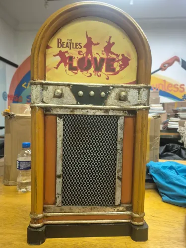 jukebox decorativa dos Beatles apresenta um design retrô em madeira com arte temática