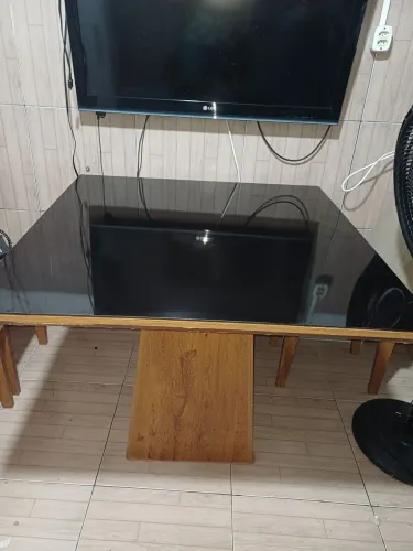 Mesa de jantar de madeira com tampo de vidro.