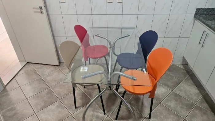Mesa de 6 lugares para cozinha com tampo em vidro e 4 cadeiras coloridas. Bom