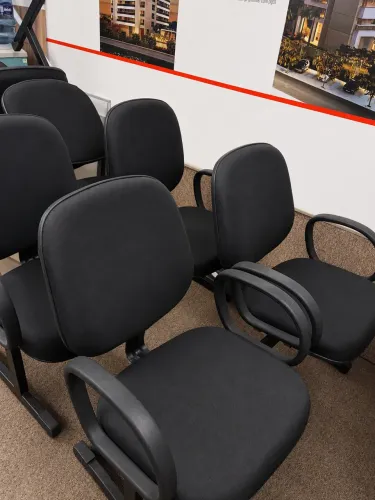 Poltronas fixas em longarina com braços e encosto.