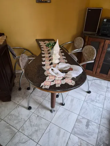Mesa forma de gota em pedra, 4 cadeiras em metal, com rodinhas.