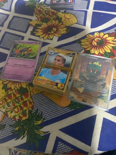 Um bolo de cards fifa23 duas cartas de Pokémon uma brilhante e uma normal