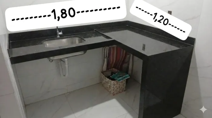 Pia em granito verde Ubatuba em formato de L com bancada mais bancada pequena suspensa 