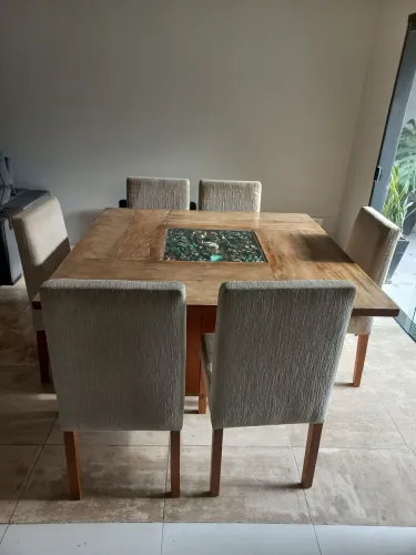 Mesa de madeira maciça com nicho decorativo central e 7 cadeiras de madeira estofadas
