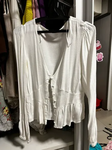 Camisa social branca de botões não é cropped, mas um pouco curta com gola v média
