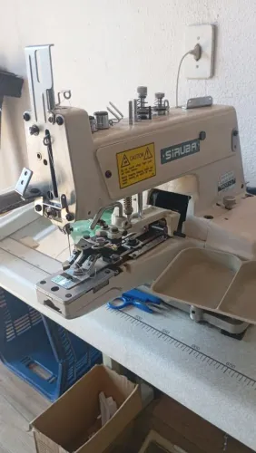 Máquina de costura e botão