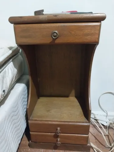 Mesa de cabeceira de madeira com 3 gavetas.