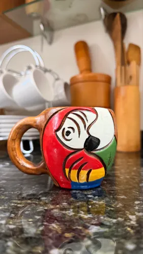 Caneca de barro com desenho de arara