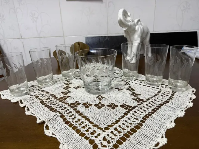 Conjunto em cristal lapidado com folhas sendo balde para gelo e seis copos longos.