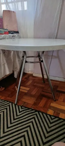 Mesa redonda branca com estrutura metálica