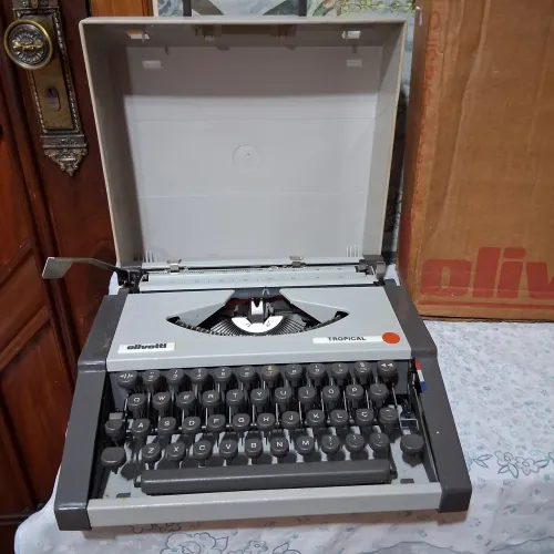 Máquina de escrever Olivetti tropical, bem conservada com manual.