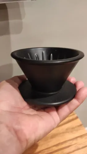 Filtro de café de porcelana na cor preta e pequena.