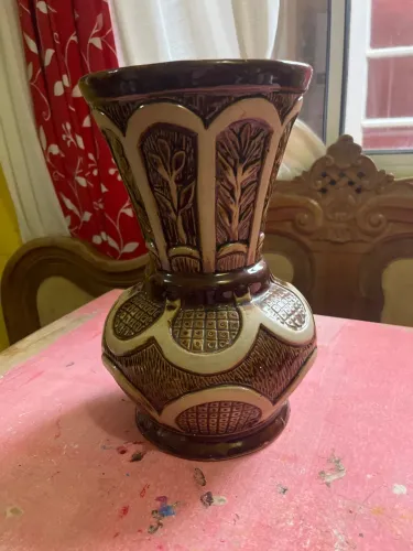 vaso em cerâmica antiga numerada, com tons em marrom e creme, e detalhes em relevo.
