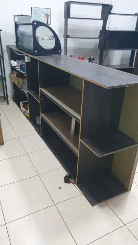 Balcão de atendimento para caixa com prateleira em MDF na cor preta.