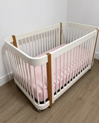 Berço 3 em 1, infantil branco com detalhes madeira e rodinhas.