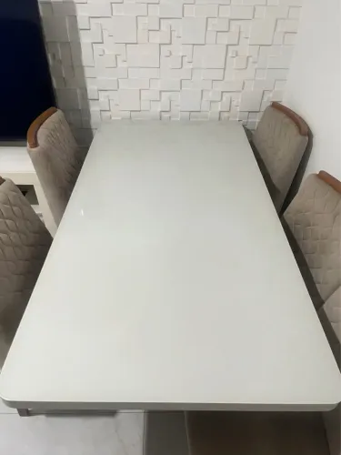 Mesa de jantar com tampo de vidro e cadeiras estofadas em perfeito estado