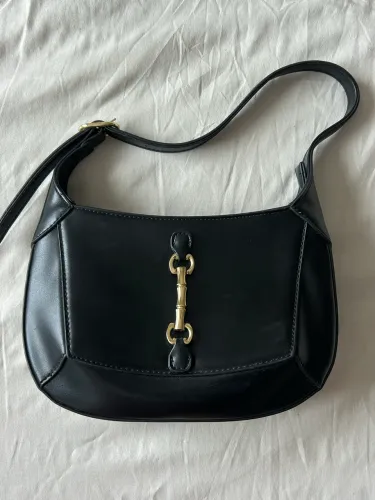 Bolsa de ombro preta com detalhe dourado