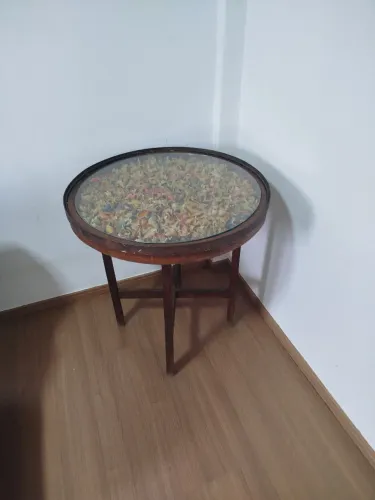 Mesa redonda de ferro com tampo de vidro com folhas secas. Pesada