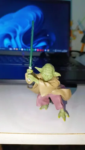 Action Figure Yoda com sabre de luz e base.