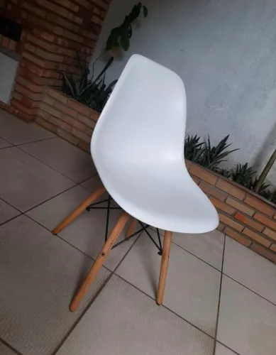Cadeira de plástico com os pés de madeira.  Produto usado 