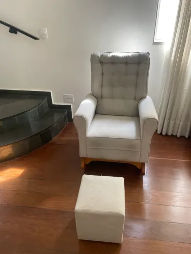 Poltrona de amamentação com banquinho de apoio para os pés .