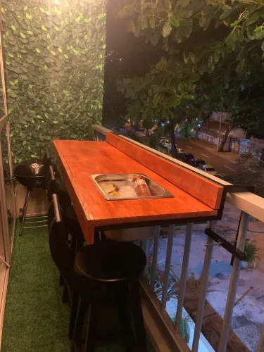 Mesa de madeira suspensa com cuba de aço e banquetas 
