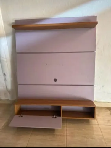 Painel para TV com rack, na cor lilás e madeira. Possui nichos e portas.